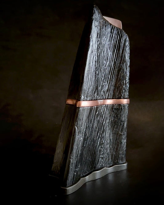 A handcrafted sculpture made of forged steel, copper, and charred oak, featuring a blend of industrial resilience and natural decay with a balance of movement and permanence.